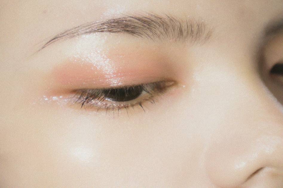 Blogger applying drugstore foundation in bright natural light