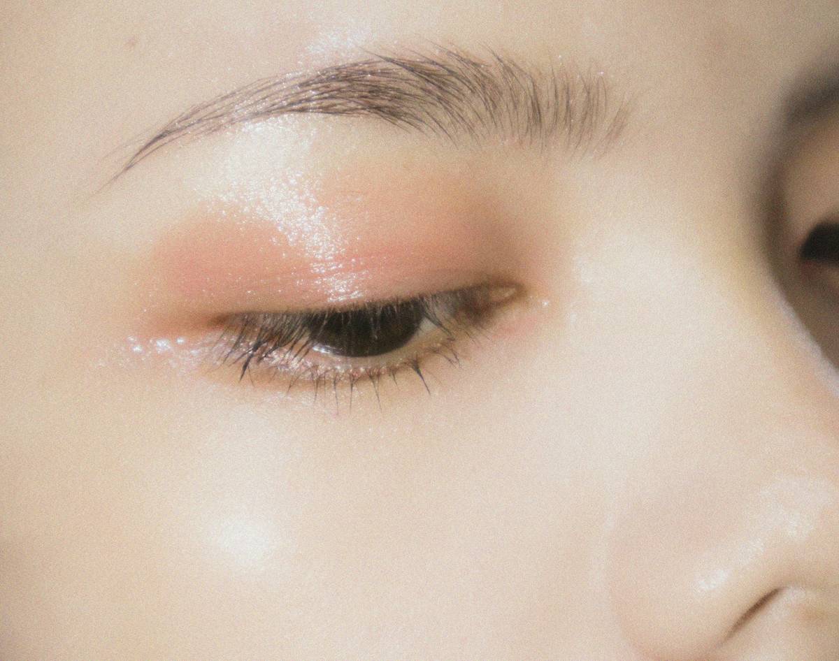 Woman applying daily mascara with precision wand close-up showing lash separation